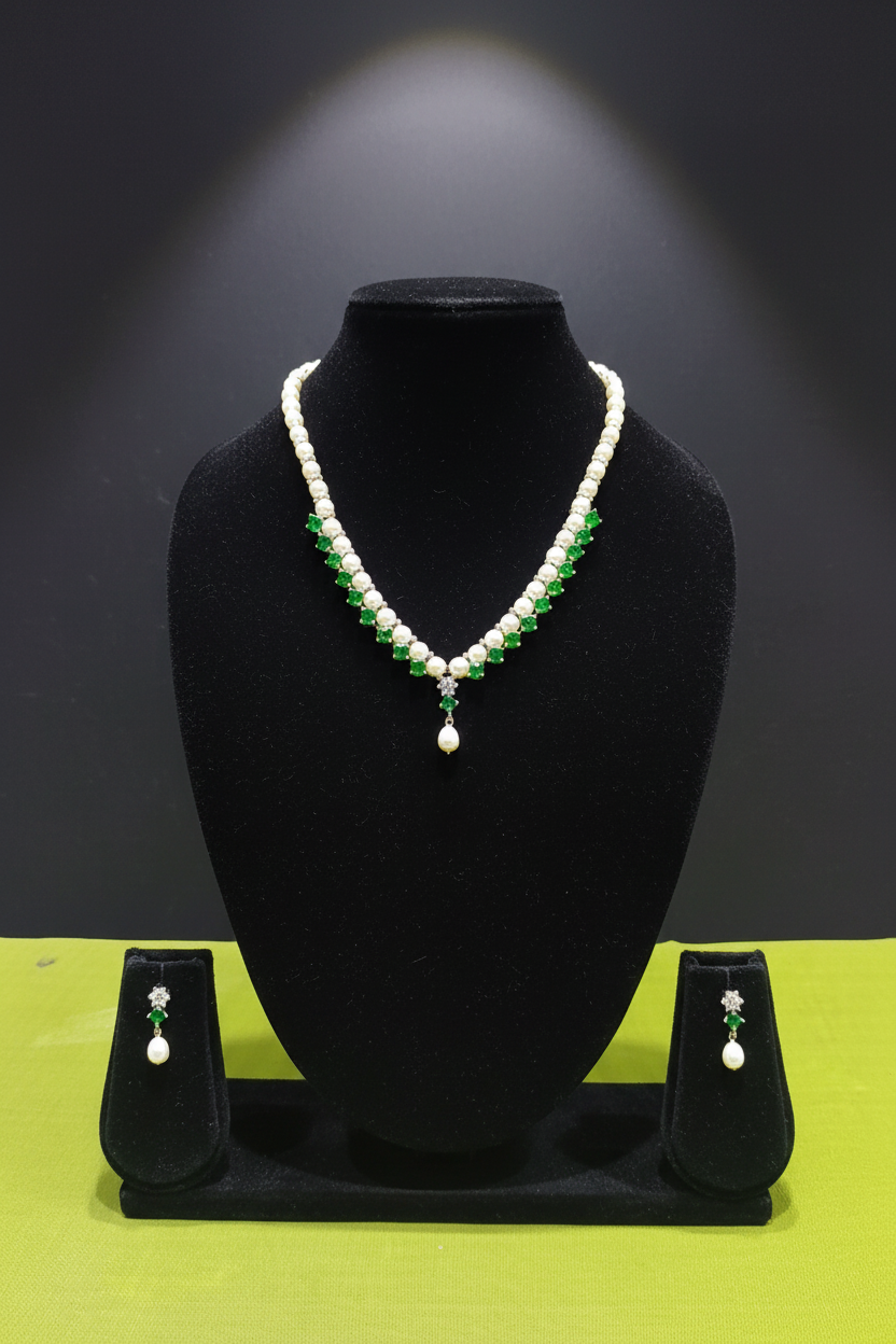 Pearl and emerald green AD necklace set with earrings on dark velvet studio display