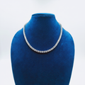 White AD graduated tennis necklace set with linear bar earrings on navy velvet display