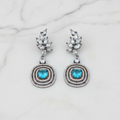 Blue topaz leaf drop earrings editorial promotional image on marble