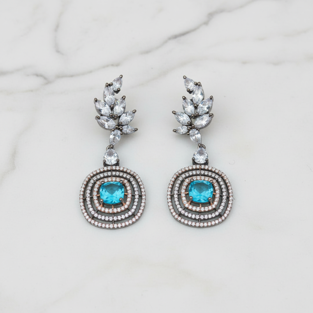 Blue topaz leaf drop earrings editorial promotional image on marble