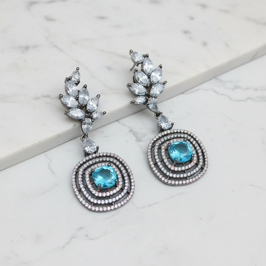 Blue topaz leaf cluster circular halo drop earrings editorial promotional image on marble
