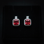 Ruby red CZ cushion halo drop earrings on black velvet - dark editorial style