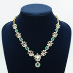 Emerald green and white AD botanical leaf necklace with pearl and emerald pendant on navy velvet display