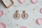 Rose gold diamond halo circle drop earrings flat lay on white marble with rose petals