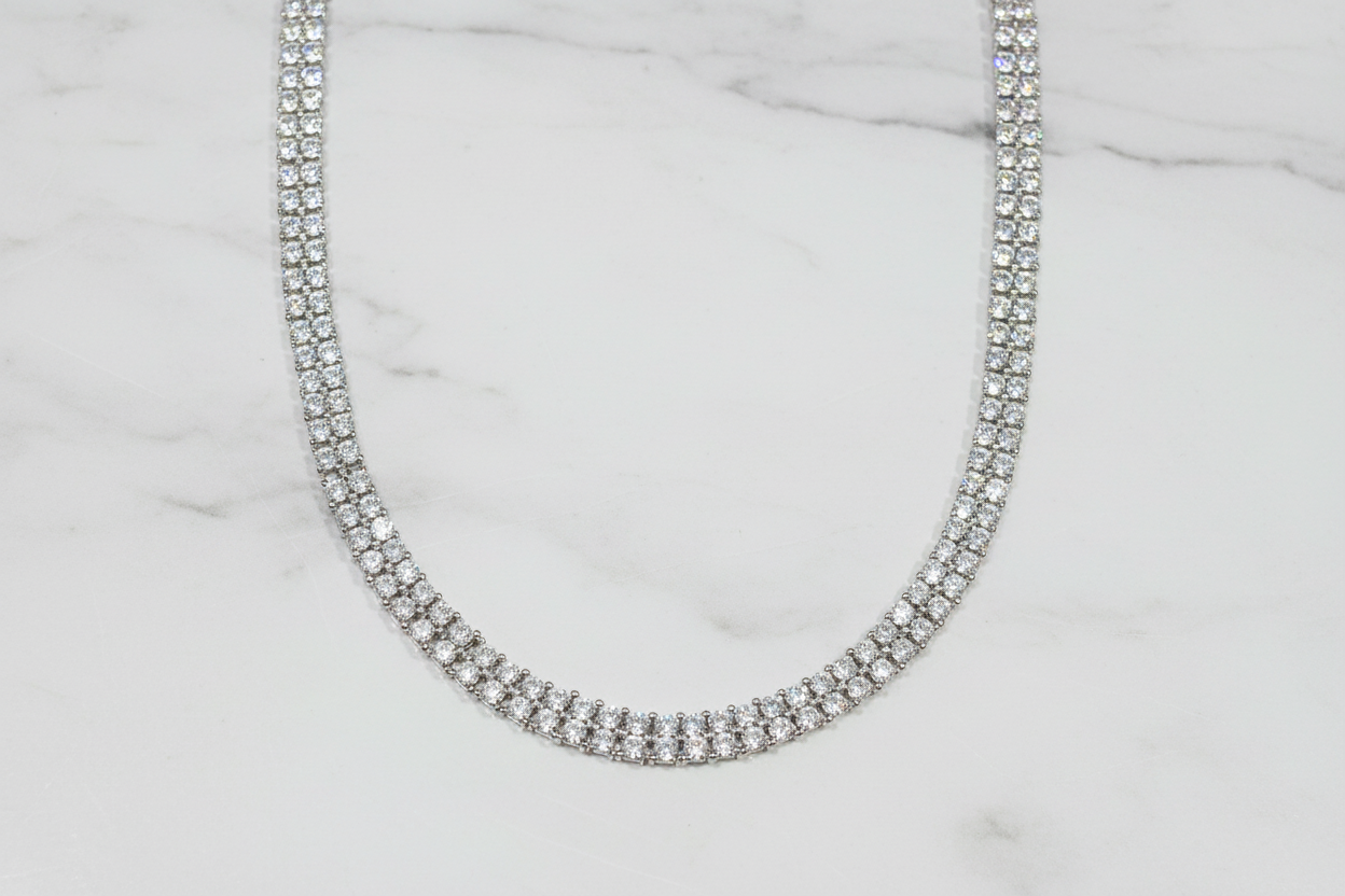 Flat lay of white AD diamond tennis necklace on white marble