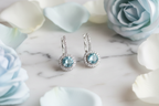 92.5 Sterling Silver Aquamarine Blue Round CZ Drop Earrings flat lay editorial shot