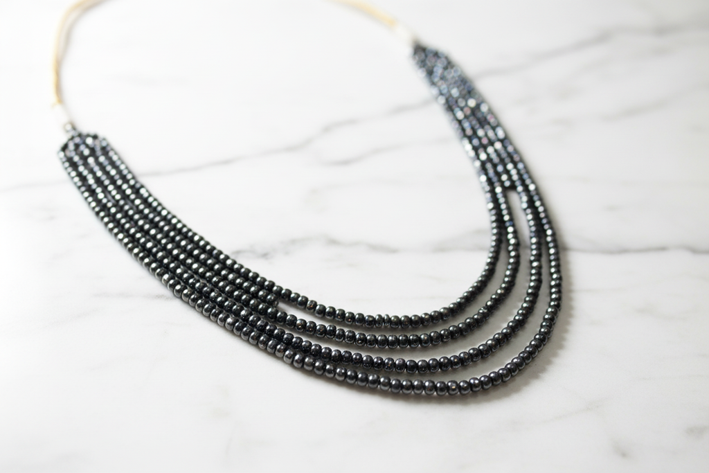 Close-up of hematite bead strands on marble