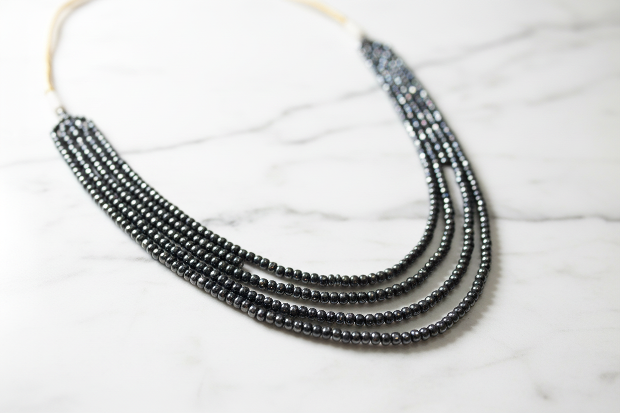 Close-up of hematite bead strands on marble