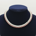 Two-tone cream and rose pearl AD X-link necklace on navy velvet bust display