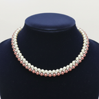 Two-tone cream and rose pearl AD X-link necklace on navy velvet bust display