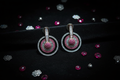 Ruby and diamond oxidised circle drop earrings flat lay on black velvet with ruby accents