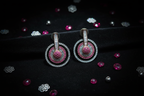 Ruby and diamond oxidised circle drop earrings flat lay on black velvet with ruby accents