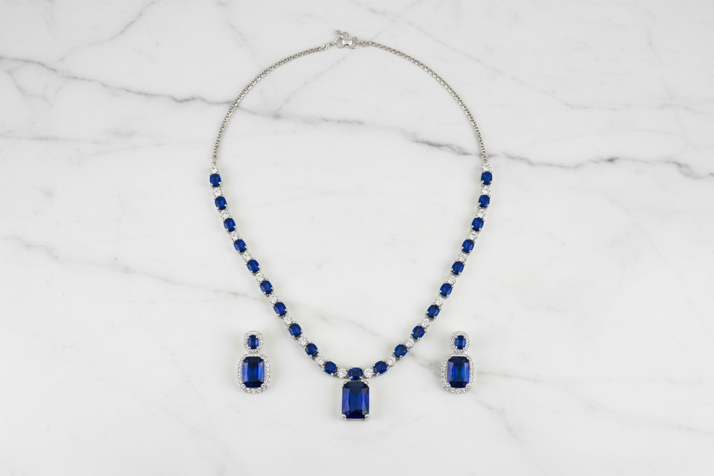 Royal blue sapphire AD tennis necklace set flat lay on white marble