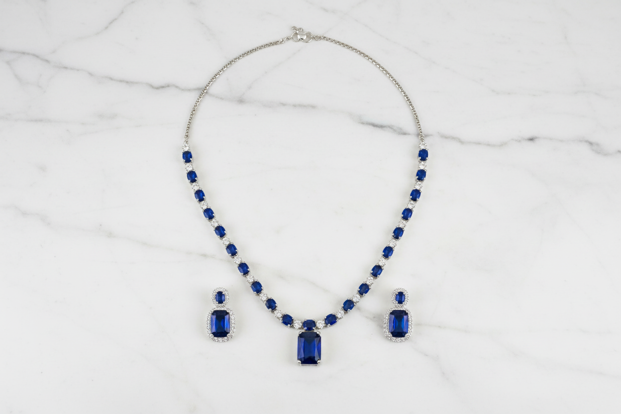 Royal blue sapphire AD tennis necklace set flat lay on white marble