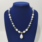 Powder blue pearl and grey AD disco ball long necklace with baroque drops on navy velvet display
