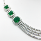 Close-up macro of emerald cushion stones and AD chain strands