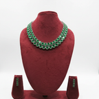 Emerald green oval AD double-row tennis necklace set with linear stud earrings on burgundy velvet display