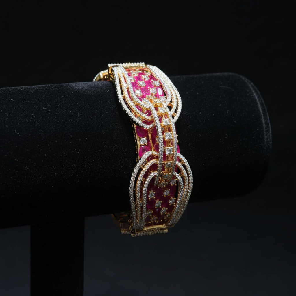 Ruby pink open-work AD bangle with gold tone arch lattice design on dark velvet studio display