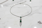 Emerald AD chain necklace flat lay on white marble