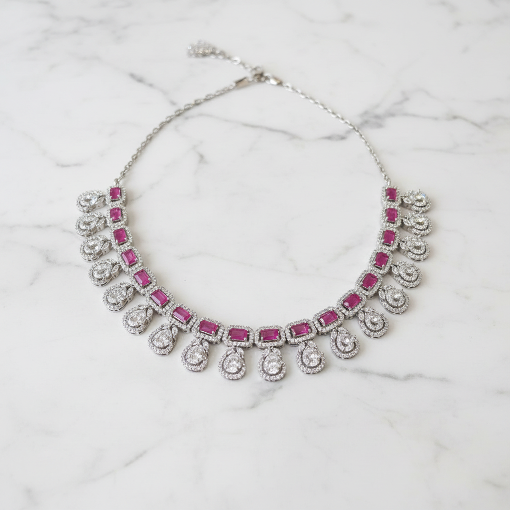 Ruby emerald-cut diamond teardrop necklace editorial promotional image on marble