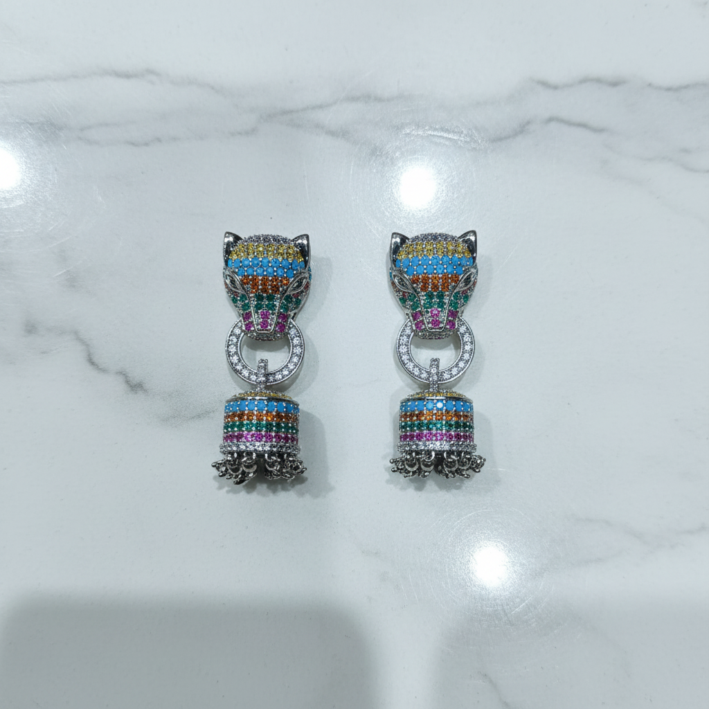 Flat lay of rainbow multicolour AD jhumka drop earrings with leopard head stud on white marble