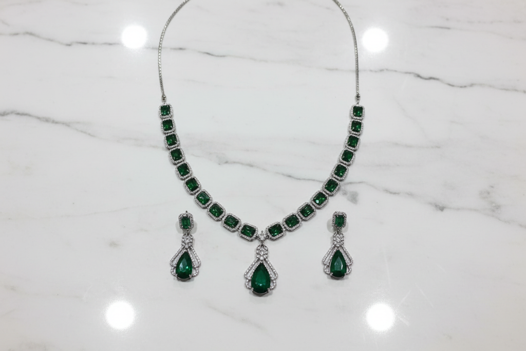 Emerald AD necklace set flat lay on white marble