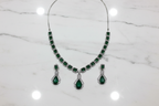 Emerald AD necklace set flat lay on white marble