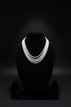4-strand layered white seed pearl necklace on dark velvet studio display