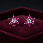 Ruby pink CZ floral star stud earrings on burgundy velvet - bold editorial style