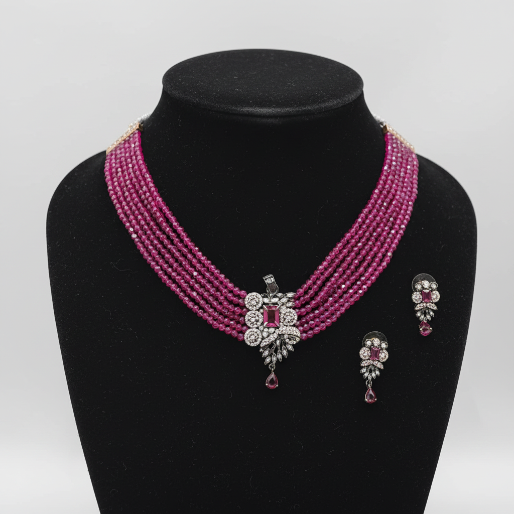 Multi-strand ruby pink crystal bead choker with oxidised silver AD butterfly centrepiece set on black velvet display