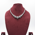 White AD floral cluster graduated tennis necklace set with drop earrings on burgundy velvet display
