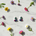 Multicolour CZ cluster drop earrings on white marble with wildflowers - vibrant lifestyle style