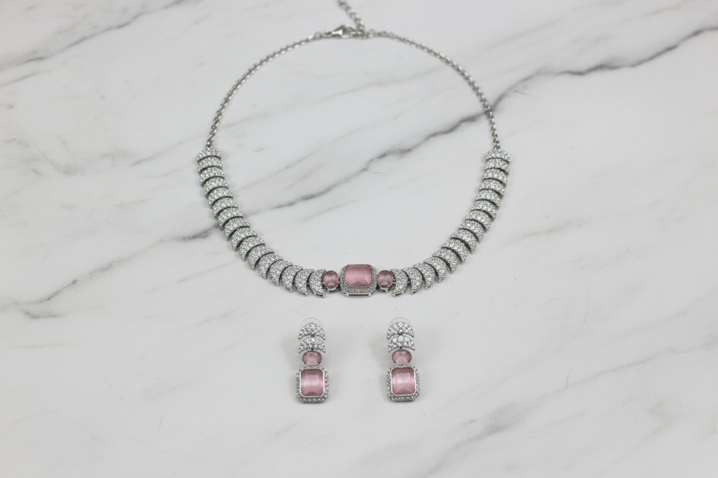 Rose pink AD pave disc necklace set flat lay on white marble