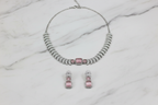 Rose pink AD pave disc necklace set flat lay on white marble