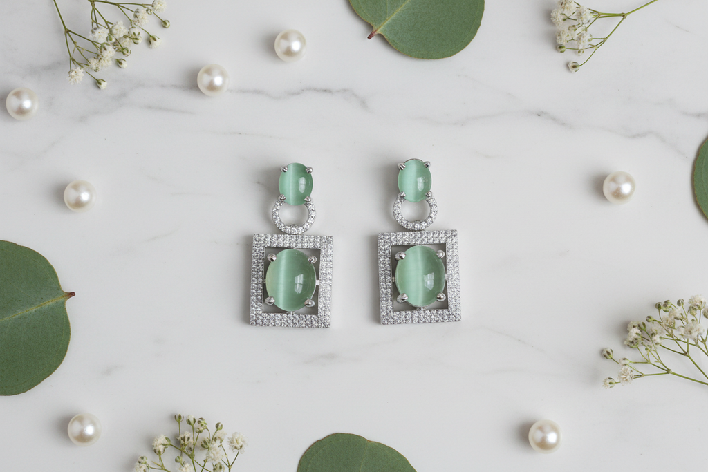 Cat's Eye Chrysoberyl Drop Earrings flat lay on white marble with pearls