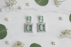 Cat's Eye Chrysoberyl Drop Earrings flat lay on white marble with pearls