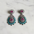 Ruby chandelier drop earrings editorial promotional image on marble