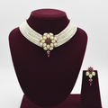 Extra-wide multi-strand seed pearl choker with ruby and emerald floral medallion set on burgundy velvet display