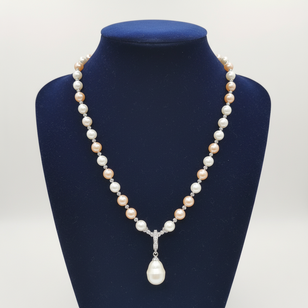 Blush pink and cream pearl AD rondelle pendant necklace with baroque drop on navy velvet display