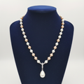 Blush pink and cream pearl AD rondelle pendant necklace with baroque drop on navy velvet display