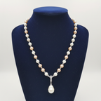 Blush pink and cream pearl AD rondelle pendant necklace with baroque drop on navy velvet display