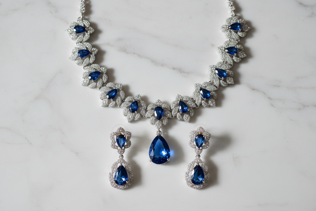 Sapphire blue floral AD necklace set flat lay on white marble