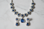 Sapphire blue floral AD necklace set flat lay on white marble