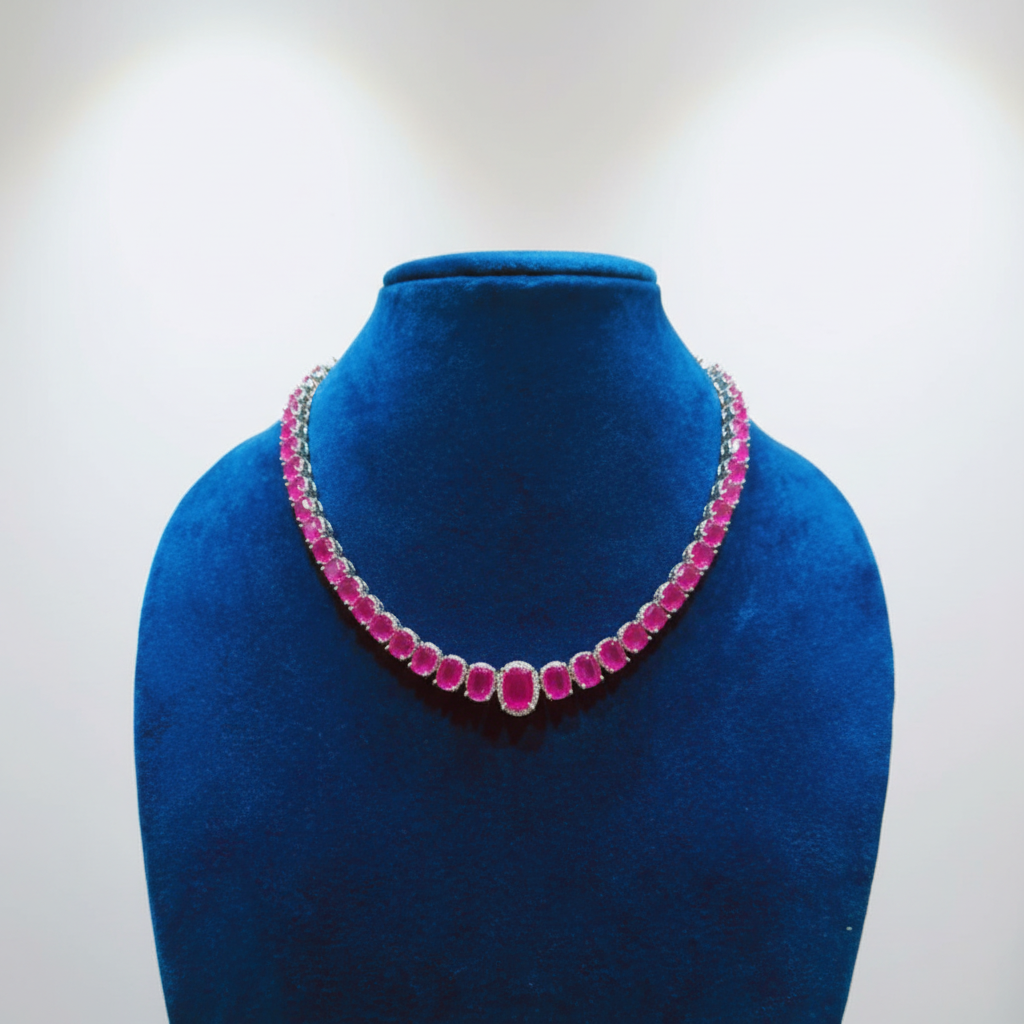 Ruby pink oval AD graduated tennis necklace set with linear stud earrings on navy velvet display